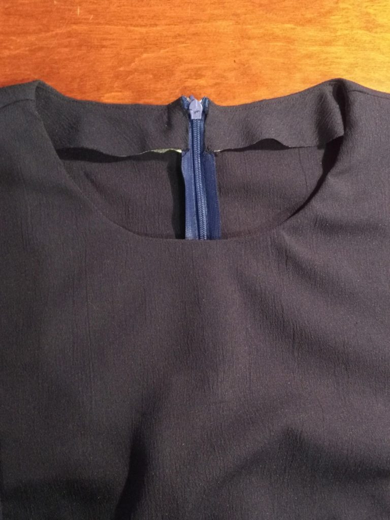 Pressed and sewn neck facing